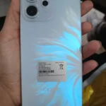 Detalhe da traseira do OPPO Reno 14F em azul, mostrando o efeito de brilho Iridescent Mermaid e o módulo de câmera tripla Sony.