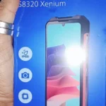 Close na caixa azul do Philips S8320 Xenium. O texto destaca "Rugged Smartphone" e ícones de especificações como certificação IP68 (resistência a água e poeira), câmera, processador e tela de 6.75 polegadas.