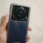 Foto real mostrando o design traseiro industrial com módulo de som gigante para comprovar se o Oukitel C60 é bom na pegada do dia a dia.