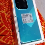 O celular Tecno Spark Go é bom? Foto mostrando o aparelho, acessórios e carregador dentro da caixa original.