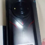 Smartphone robusto Hotwav T7 na cor preta com detalhes vermelhos em sua embalagem original, comprovando que o hotwav t7 é bom e bem acabado.
